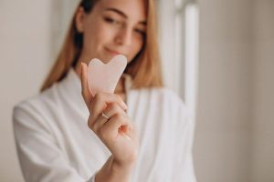 woman with anti-aging gua sha at home